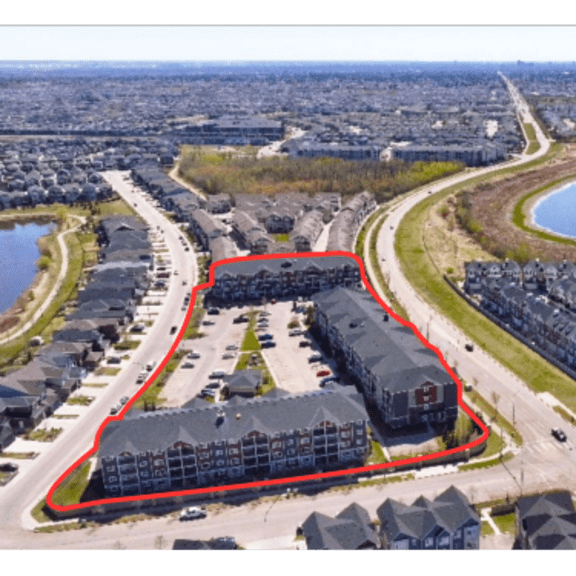 a bird's eye view of a residential area with a lake and a road.