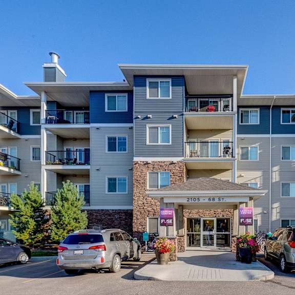 a large apartment complex with a stone entrance and multiple balconies.
