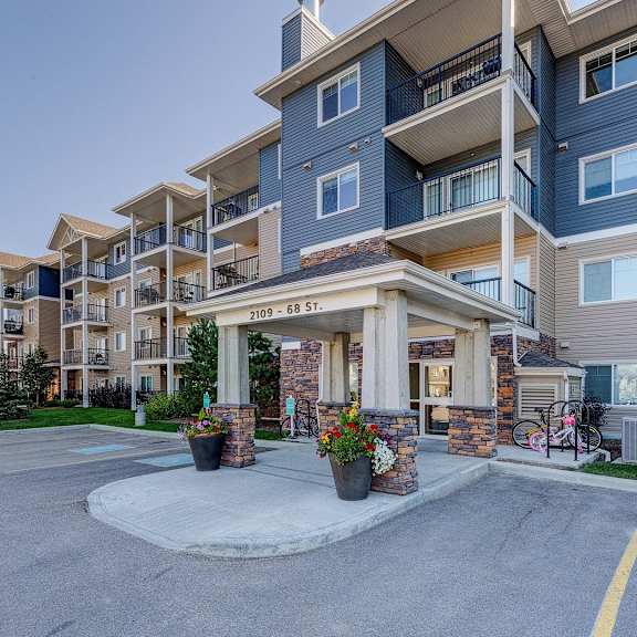 apartment building with a front entrance and a bicycle parked by the entrance.