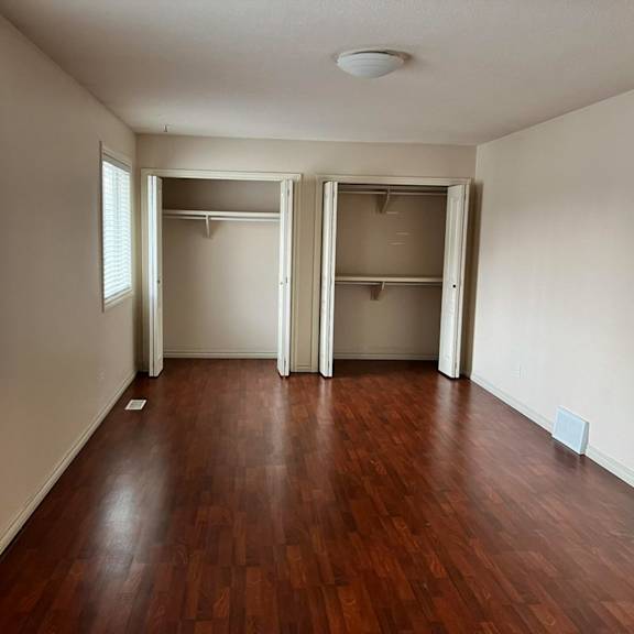 empty room with wood flooring and white walls.