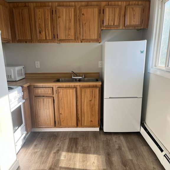a kitchen with wooden cabinets and a white refrigerator.