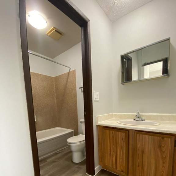 a bathroom with a wooden cabinet and a white sink.