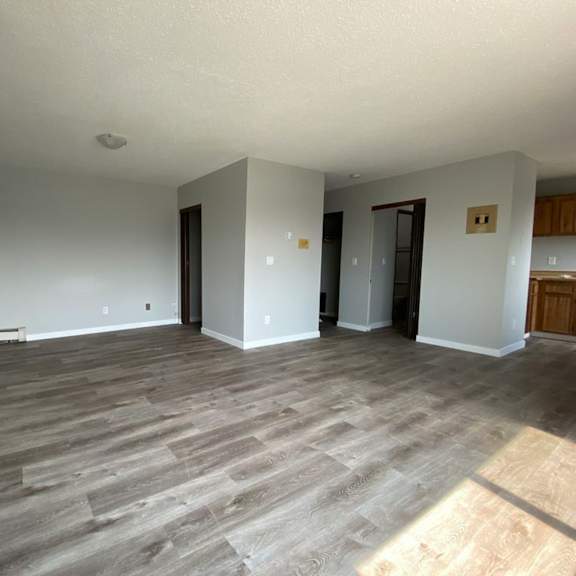 a room with wooden flooring and white walls.