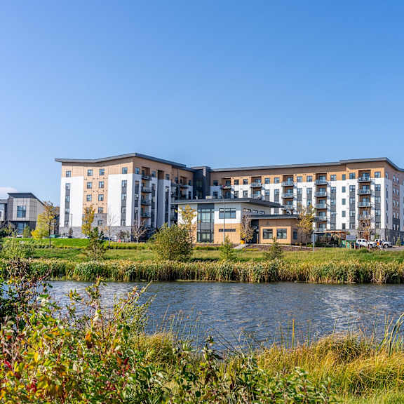 a modern building complex with a body of water in front.