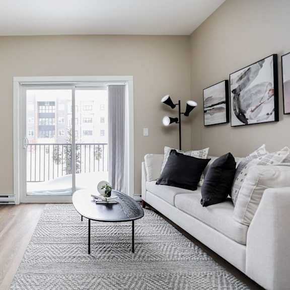 a living room with a white couch, a coffee table, and a television.