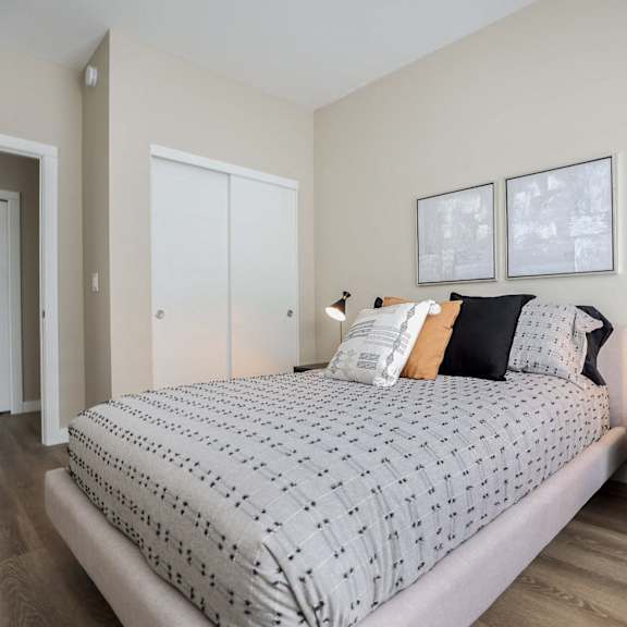 a bedroom with a large bed and a small table with a plant on it.