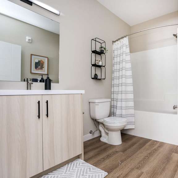 a bathroom with a toilet, sink, and a shower.