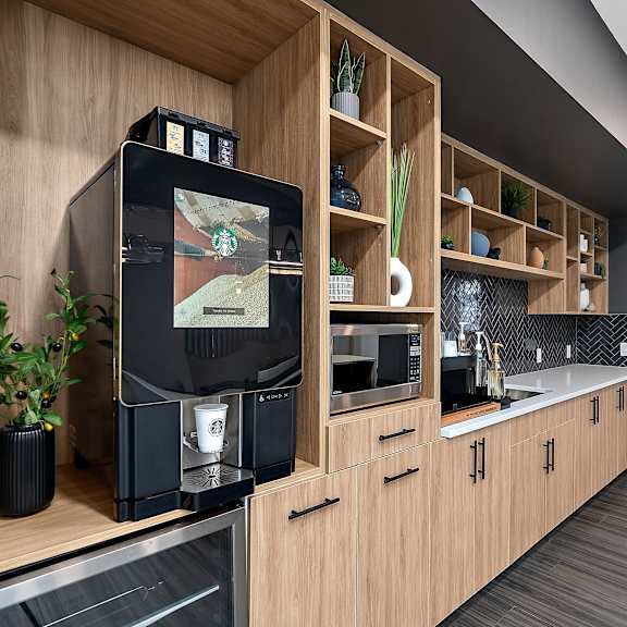 a kitchen with wooden cabinets and a black coffee machine in it