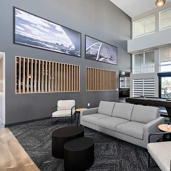 a living room with a gray couch and a pool table