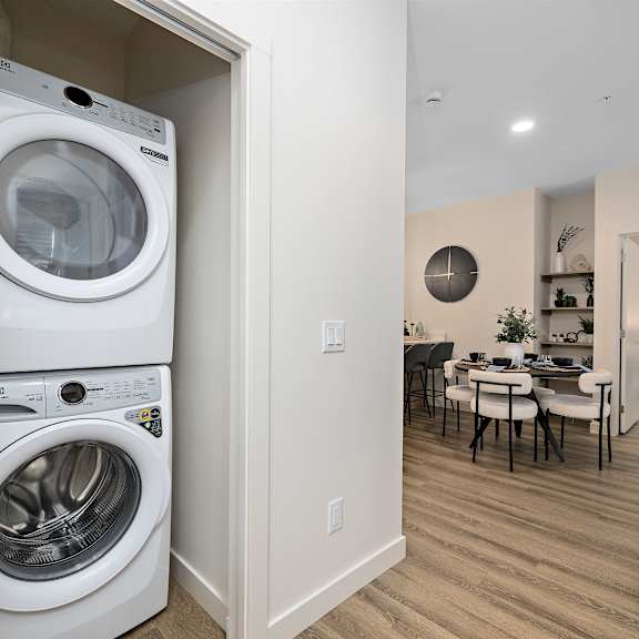 a washer and dryer in a living room next to a dining room table