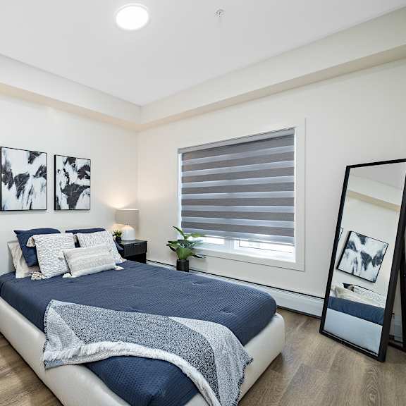 modern bedroom with navy blue bedding at mac and mullen apartments, alberta