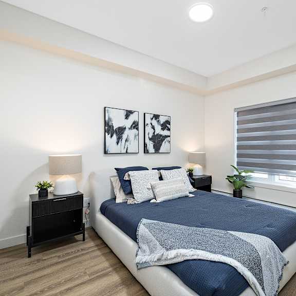 a bedroom with a large bed and a window with a blue blanket