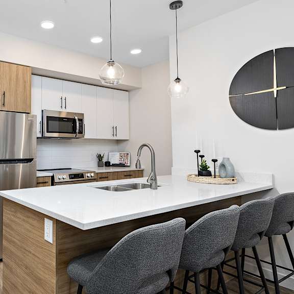 modern kitchen with breakfast bar seating at mac and mullen apartments, edmonton, ab t6r 0s7