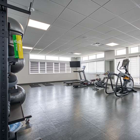 a gym with treadmills, exercise bikes, and other equipment.