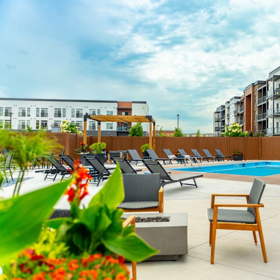 a pool area with chairs and a sign that says "no lifeguard on duty".