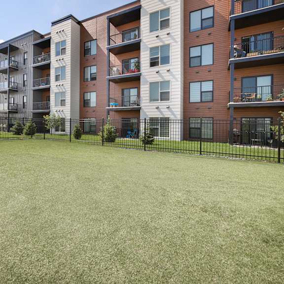 a large grassy area in front of apartment buildings.