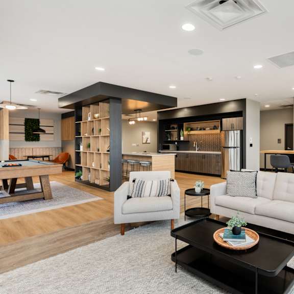 a modern living room with a white sofa, a black coffee table, and a wooden floor.