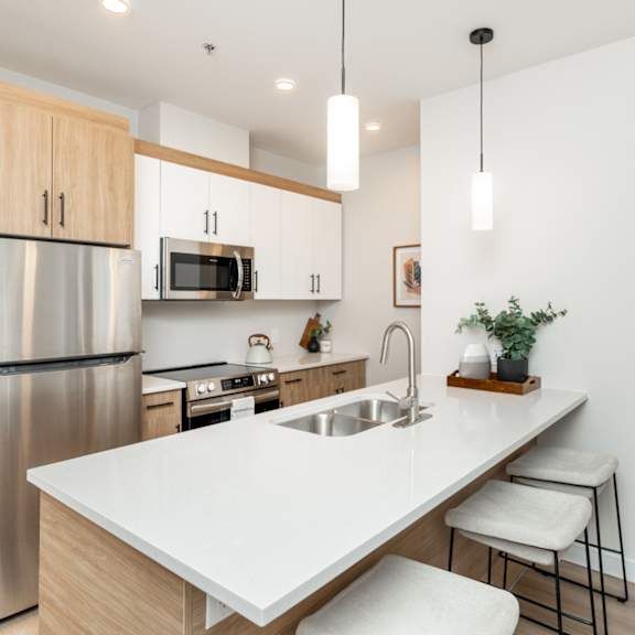 a modern kitchen with a stainless steel refrigerator and a white countertop.
