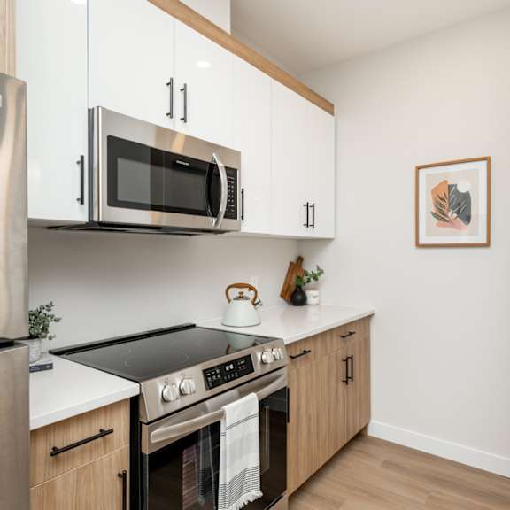 a modern kitchen with stainless steel appliances and wooden cabinets.