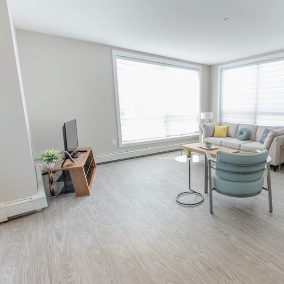 a living room with a grey sofa and a white chair.