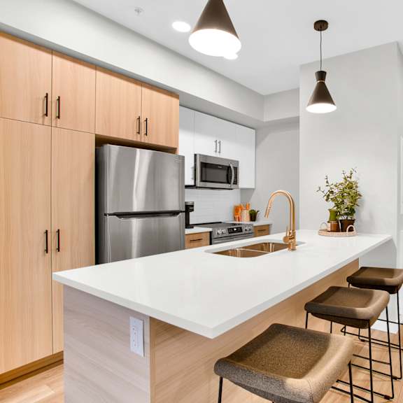 modern kitchen with breakfast bar seating at plaza apartments, calgary, alberta