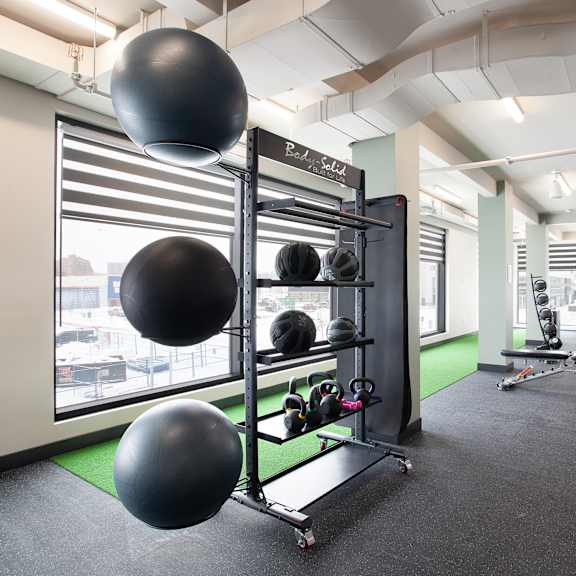modern fitness center with exercise equipment at plaza apartments, alberta