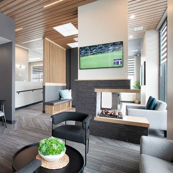modern clubhouse lounge with fireplace and dining area at plaza apartments, calgary, t2l 2m8