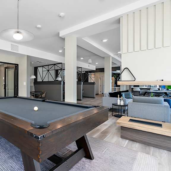 a pool table is in the middle of a room with a glass wall.