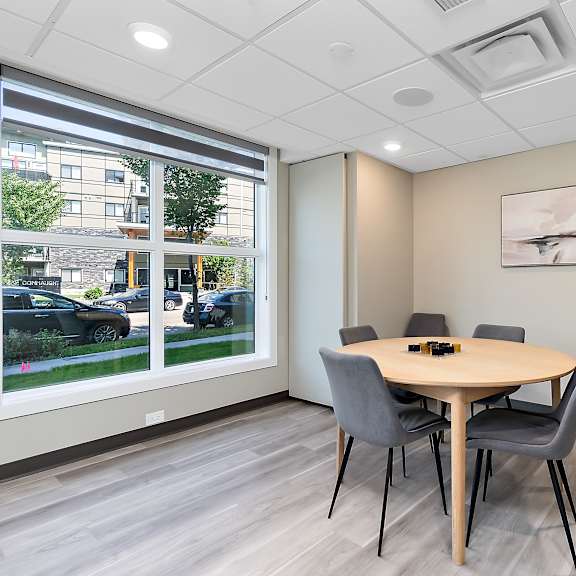 a conference room with a table, chairs, and a plant.