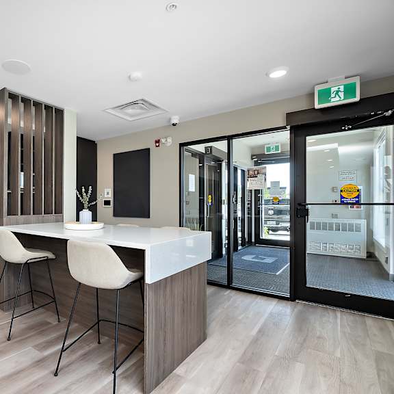 a modern kitchen with a bar area and a dining table.