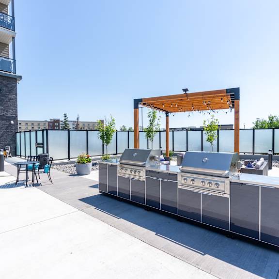 a modern outdoor kitchen area with a grill and seating area.