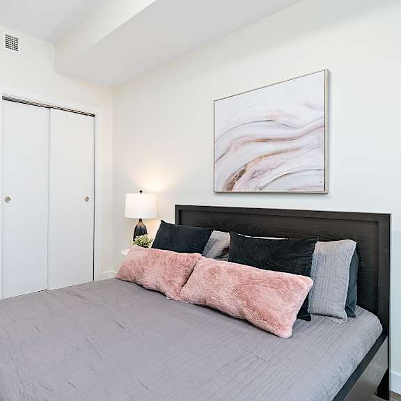 a bedroom with a large bed and a painting on the wall.