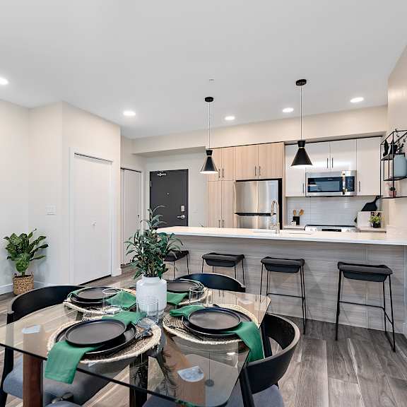 a modern dining room with a glass table and chairs.