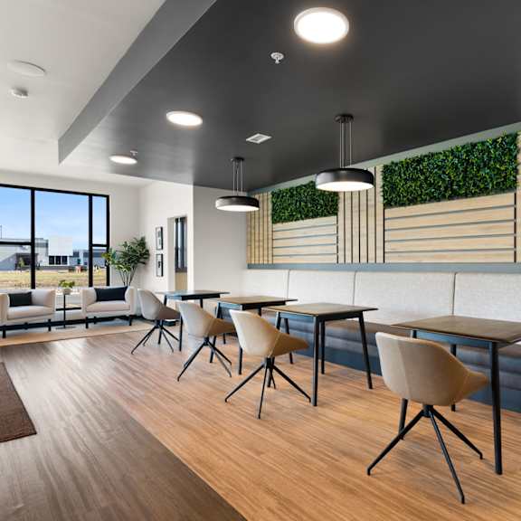 a modern dining area with wooden floors and white walls.
