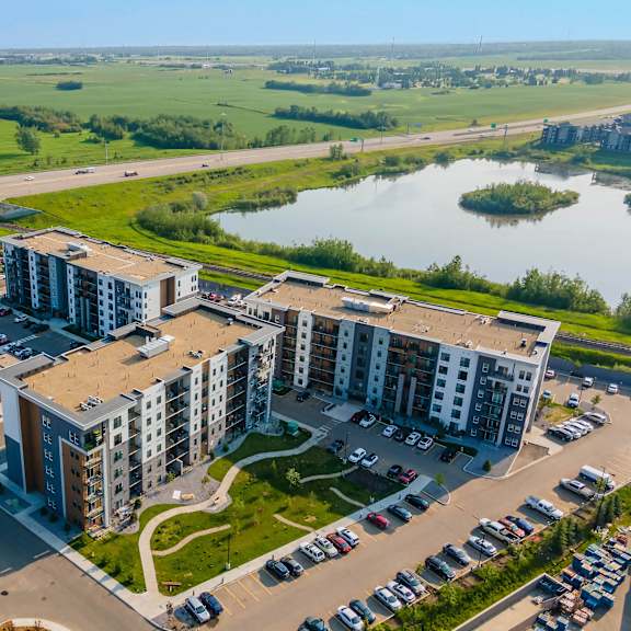 a bird's eye view of a residential area with apartment buildings and a parking lot.