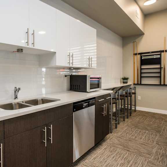 a modern kitchen with white countertops and brown cabinets.
