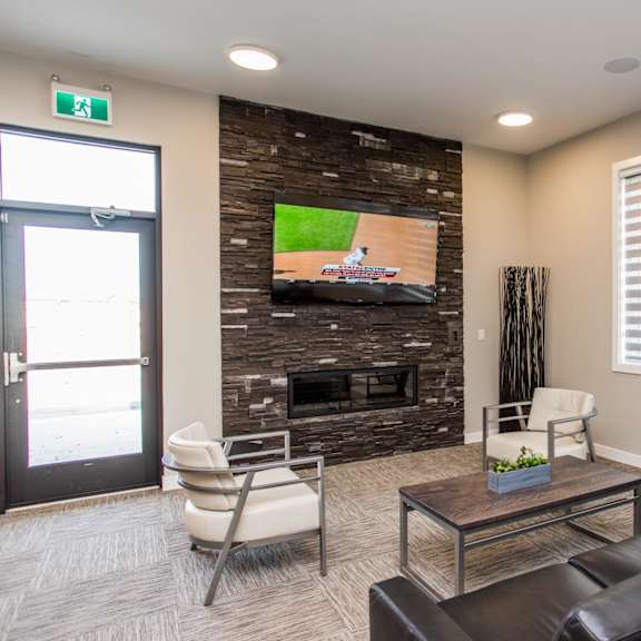 a living room with a flat screen tv mounted on a stone wall.