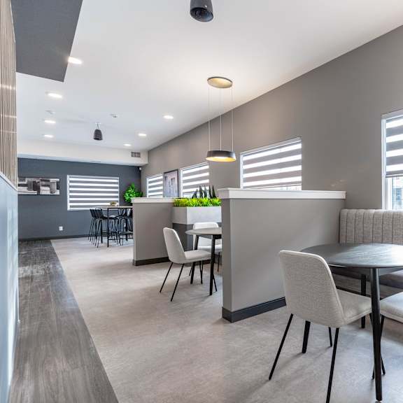 a modern dining area with a table set for four.at vibe apartments at arbour lake, alberta, t3g 4j2