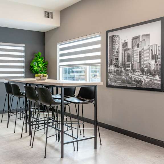 a room with a table and chairs and a picture on the wall.at vibe apartments at arbour lake, calgary alberta