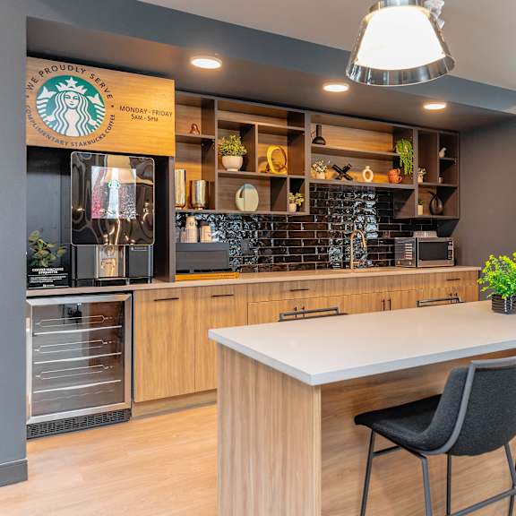 a starbucks coffee shop interior with a counter and chairs.at vibe apartments at arbour lake, calgary, ab t3g 4j2