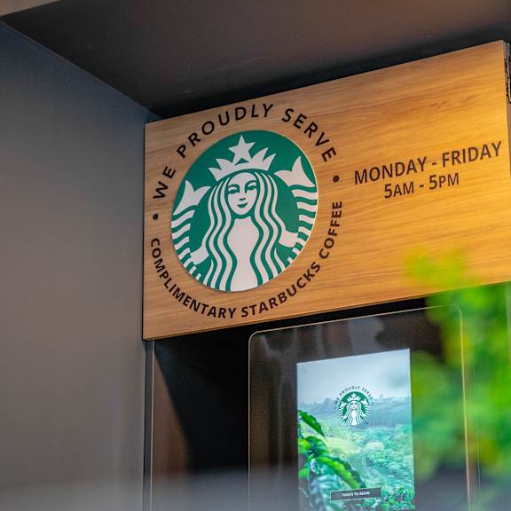 a starbucks sign is hanging on the wall.at vibe apartments at arbour lake, calgary, ab