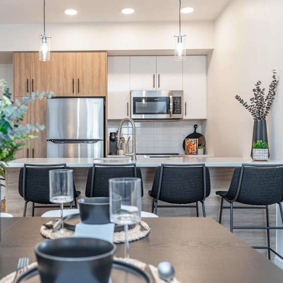 a modern dining room with a table set for six.at vibe apartments at arbour lake, calgary, t3g 4j2