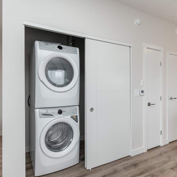 a white washing machine and dryer in a modern laundry room.at latitude 49 townhomes, winnipeg, mb r3x 0m1