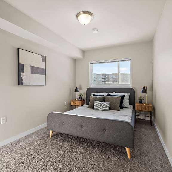 a bedroom with a bed, nightstands, and a window.