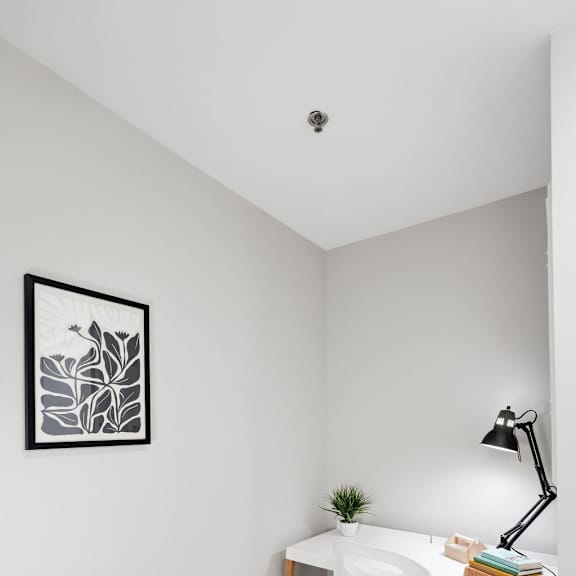 a small desk with a white chair and a lamp on it.