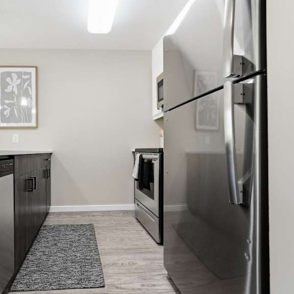 a modern kitchen with a refrigerator on the right side.