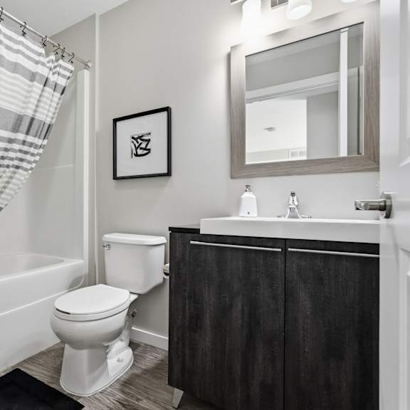 a bathroom with a toilet, sink, and shower curtain.