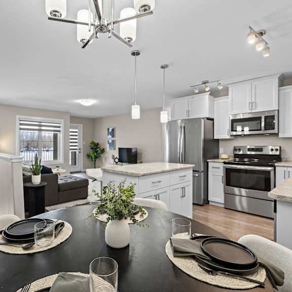 a modern kitchen with a dining table set for two.