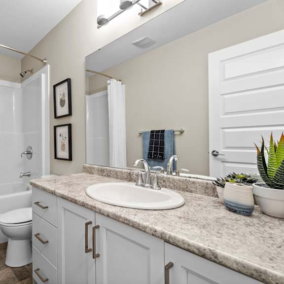 a bathroom with a white toilet, sink, and bathtub.