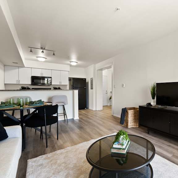 a modern living room with a black coffee table and a flat screen tv.